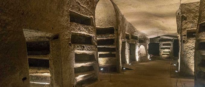 The tunnels of Naples Underground, featuring a hall with carved loculi (cavities).