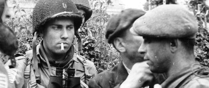 Members of the French Resistance and the US 82nd Airborne division converse