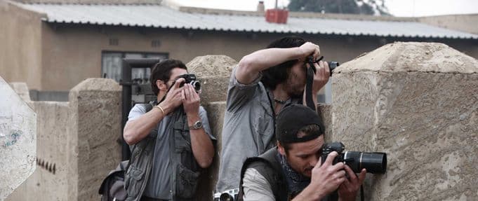 three photographers take shots in a still from 'the bang bang club'