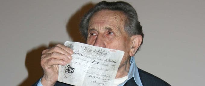 holocaust survivor Adolf Burger poses with a forged British bank note from Operation Bernhard