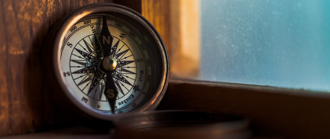 a compass sitting on a wooden window sill